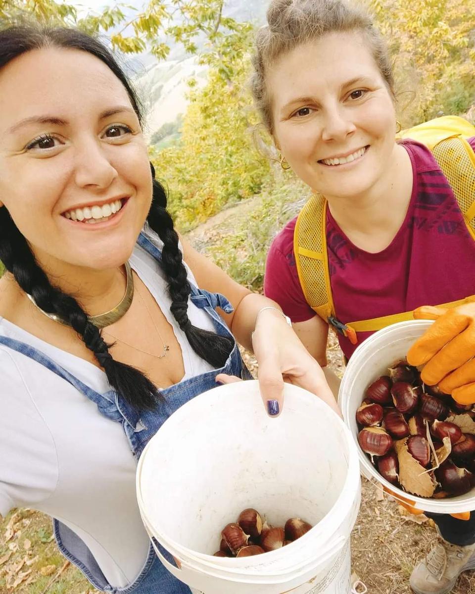 Due amiche con i secchi di castagne raccolte