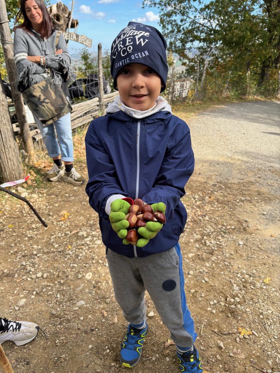 Bambino con le mani piene di castagne