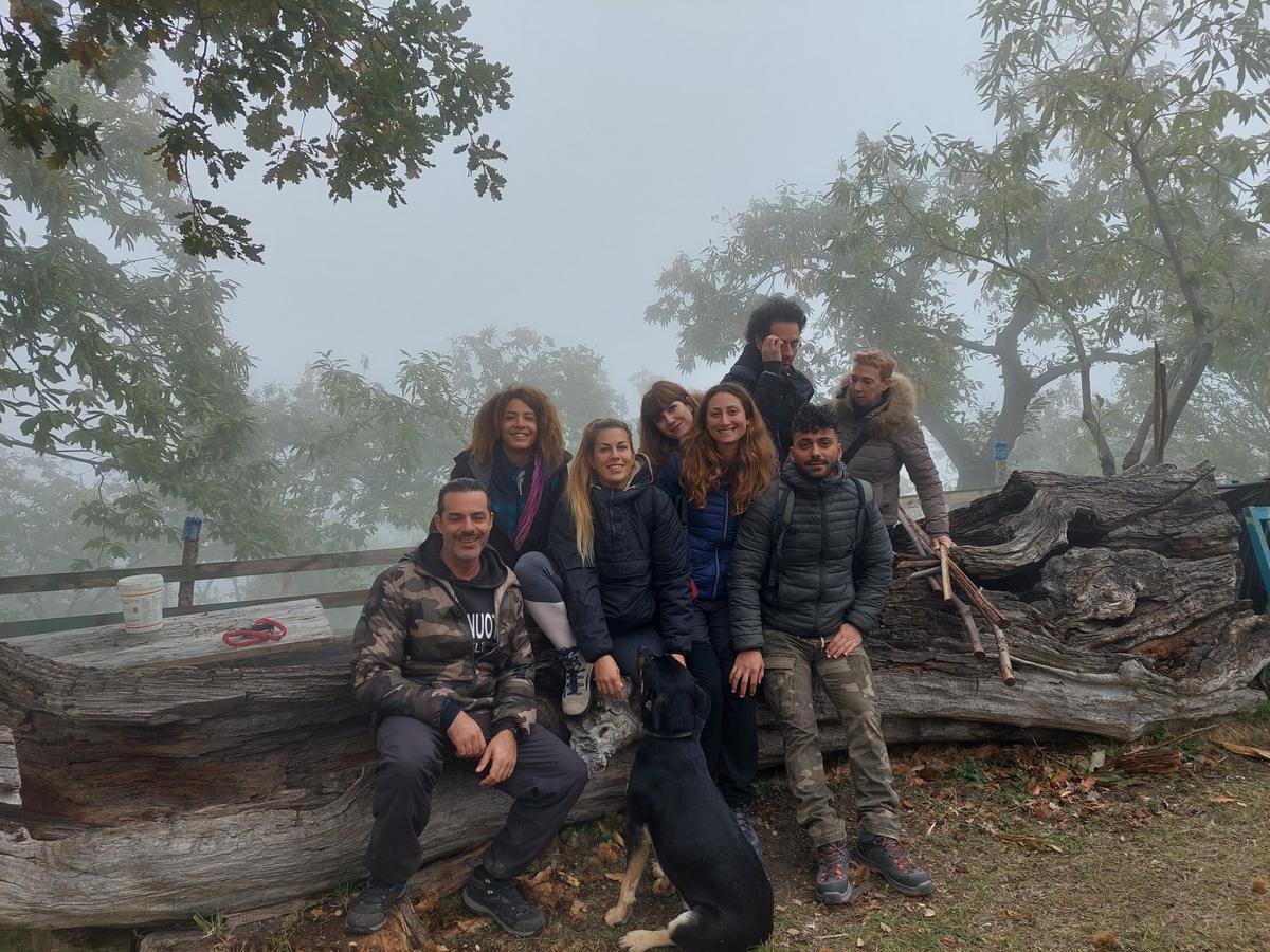 Un gruppo di amici seduti sul tronco nella nebbia