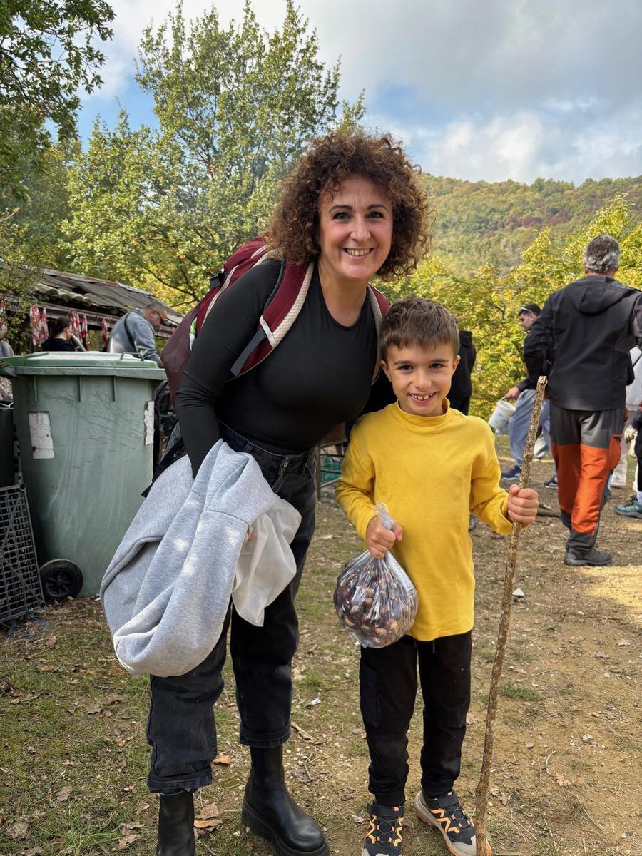 Mamma e bambino con il sacchetto di castagne