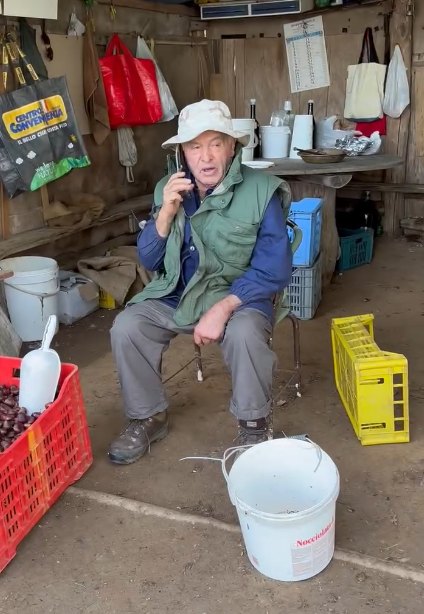 Pietro Belloni al telefono nella capanna del Castagneto Monte Pincio, accanto alle cassette di marroni